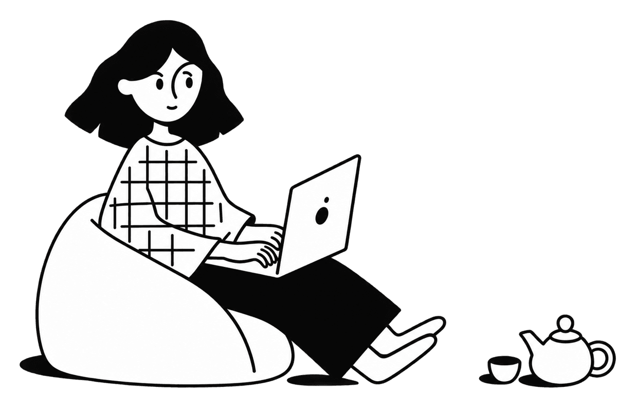 A student working on a laptop in a bean bag with a teapot beside them